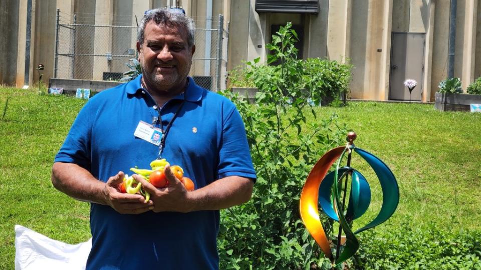 A smiling man holding vegetables