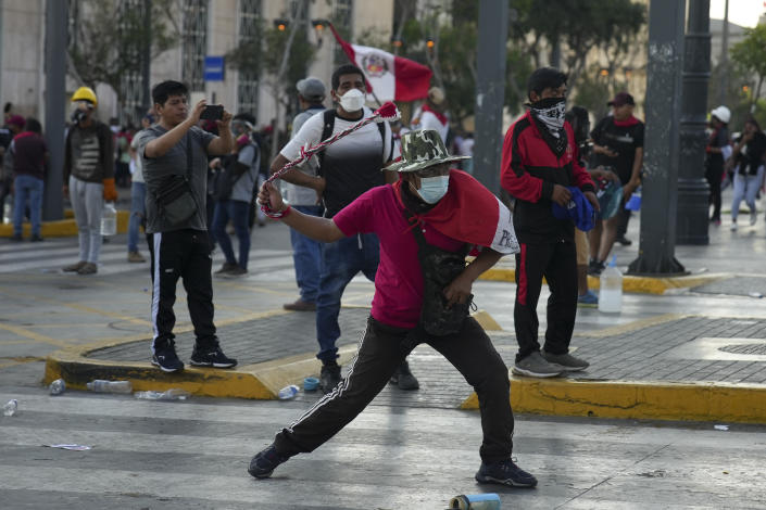 Anti-government protesters clash with police in Lima, Peru, Tuesday, Jan. 24, 2023. Protesters are seeking the resignation of President Dina Boluarte, the release from prison of ousted President Pedro Castillo, immediate elections and justice for demonstrators killed in clashes with police. (AP Photo/Guadalupe Pardo)