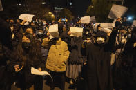 Protesters hold up blank papers and chant slogans as they march in protest in Beijing, Sunday, Nov. 27, 2022. The recent wave of protests against China's anti-virus restrictions was a ray of hope for some supporters of Hong Kong's own pro-democracy movement after local authorities stifled it using a national security law enacted in 2020, but not everyone agrees. (AP Photo/Ng Han Guan)