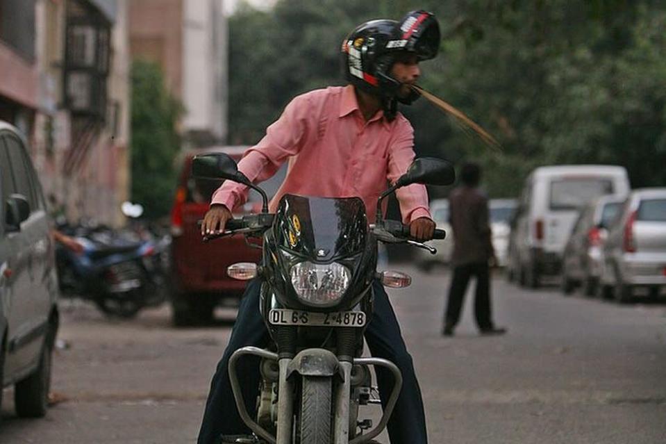 Un automobiliste crache de la noix de bétel mâchée sur la route au mépris total de la propreté et de l'esthétique à New Delhi le 29 septembre 2009.