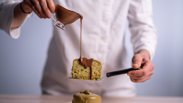 Pouring chocolate sauce on cake