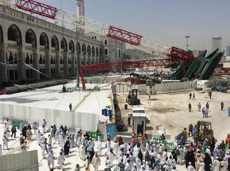 Muslim pilgrims walk near a construction crane which crashed in the Grand Mosque in the Muslim holy city of Mecca, Saudi Arabia September 12, 2015. REUTERS/Mohamed Al Hwaity