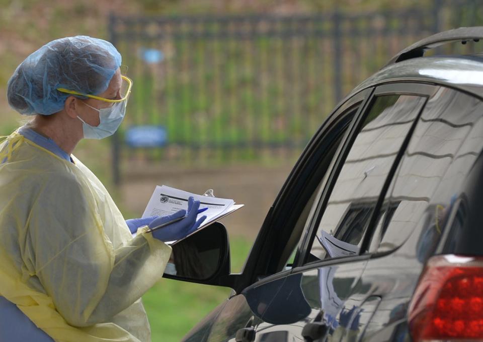 An AdventHealth Medical Group member asks questions of a patient March 19, 2020 as  teams provide COVID-19 testing for patients outside Medical Office Building at 50 Hospital Drive, Hendersonville.