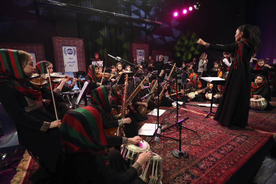 In this Wednesday, Feb. 15, 2017 photo, orchestra conductor Zarifa Adiba, 18, performs during a concert in Kabul. Afghanistan’s first all-female symphony is trying to change attitudes in a deeply conservative country where many see music as immoral, especially for women. (AP Photo/Rahmat Gul)