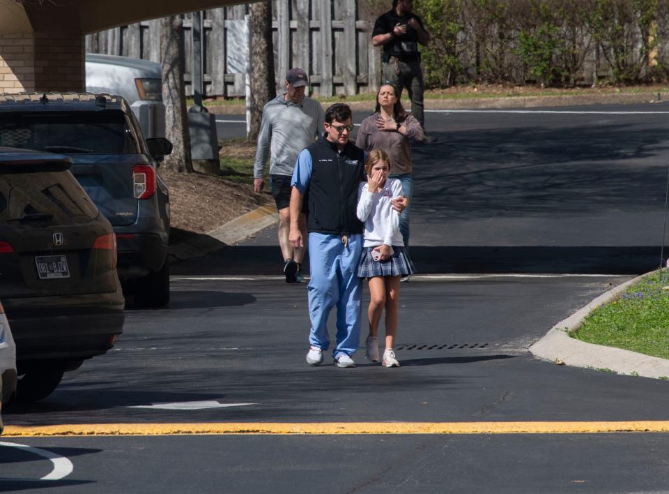 Parents console their children while leaving Woodmont Baptist following a school shooting that occurred Monday morning at Covenant School, in Nashville , Tenn., Monday, March 27, 2023.