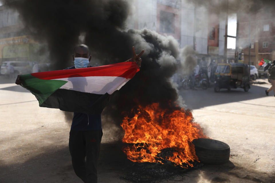 A demonstrator gives the victory sign during a protest, in Khartoum, Sudan, Saturday, Dec. 19, 2020. Protests in Sudan’s capital and across the country are demanding a faster pace to democratic reforms, in demonstrations that are marking the two-year anniversary of the uprising that led to the military’s ouster of strongman Omar al-Bashir. (AP Photo/Marwan Ali)