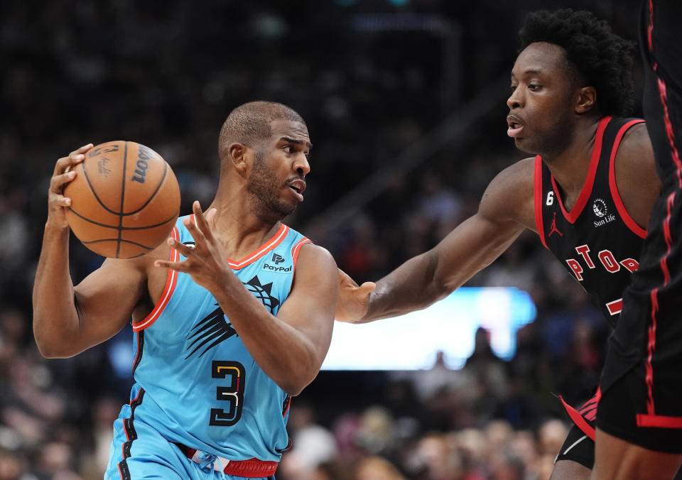Phoenix Suns guard Chris Paul, left, protects the ball from Toronto Raptors forward O.G. Anunoby, right, during first-half NBA basketball game action in Toronto, Friday, Dec. 30, 2022. (Frank Gunn/The Canadian Press via AP)