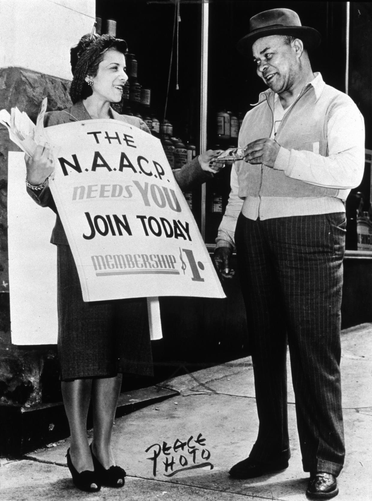 circa 1945: A women hands a flyer to a man looking to join the NAACP (National Association for the Advancement of Coloured People). The NAACP was founded in 1909 on Abraham Lincoln's birthday after a riot had broken out the year before in his home town of Springfield, Illinois.   (Photo by MPI/Getty Images)
