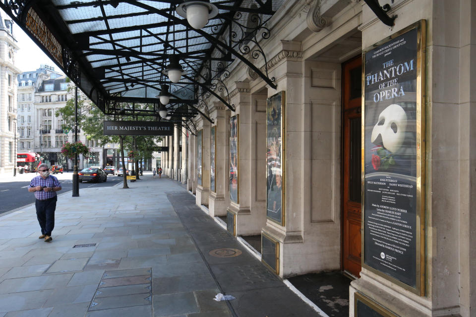 A man wearing a face mask walks past Her Majesty's Theatre in Haymarket, London, which used to show The Phantom Of The Opera before it closed because of the coronavirus pandemic. The Covid-19 crisis has wreaked havoc in the West End, where theatres have been dark since March.