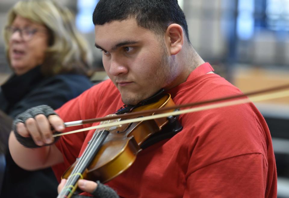 Senior Daniel Maldonado plays the Hot Cross Bun song in teacher Elijah Langille's Modern Orchestra class in a music room at Barnstable High School.