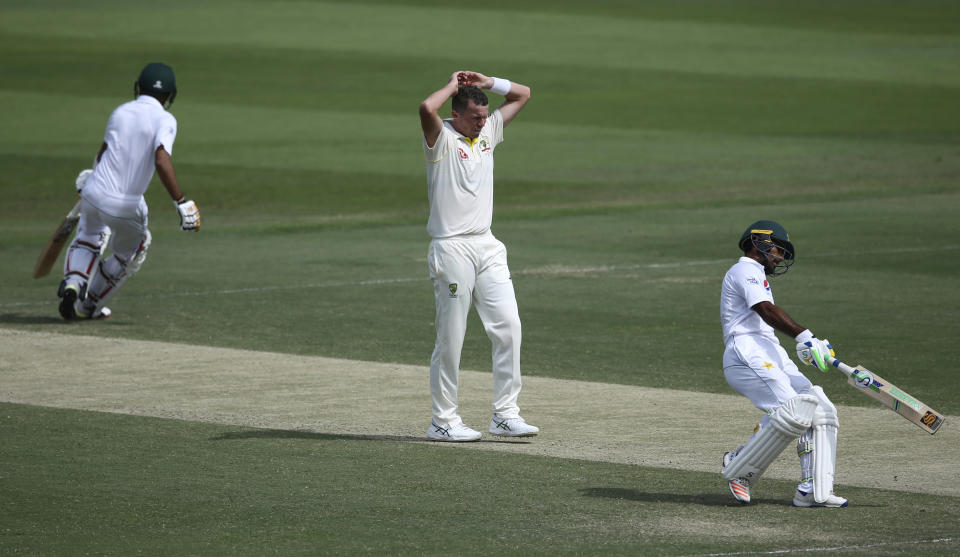 Australia's Peter Siddle, center, reacts as Pakistan's Asad Shafiq and Babar Azam runs between the wicket during their cricket test match in Abu Dhabi, United Arab Emirates, Thursday, Oct. 18, 2018. (AP Photo/Kamran Jebreili)