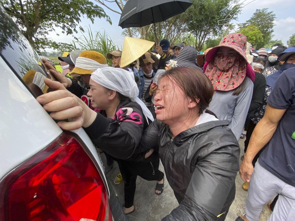 The sisters of Bui Thi Nhung weep as they walk behind the ambulance that carries Nhung's casket on Saturday, Nov. 30, 2019 in the village of Do Thanh, Vietnam. The body of 19-year old Nhung was among the last remains of the 39 Vietnamese who died while being smuggled in a truck to England last month that were repatriated to their home country on Saturday. (AP Photo/Hau Dinh)