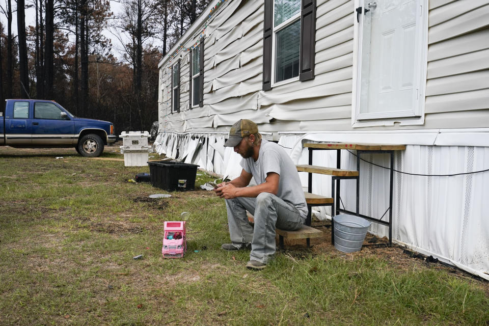 William McCarthy sits on the steps of his home that was heavily damaged from a wildfire in Evans, La., Wednesday, Sept. 13, 2023. (AP Photo/Gerald Herbert)