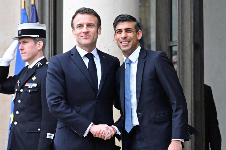 Emmanuel Macron shakes hands with Britain's Prime Minister Rishi Sunak as he arrives for their meeting (AFP via Getty Images)