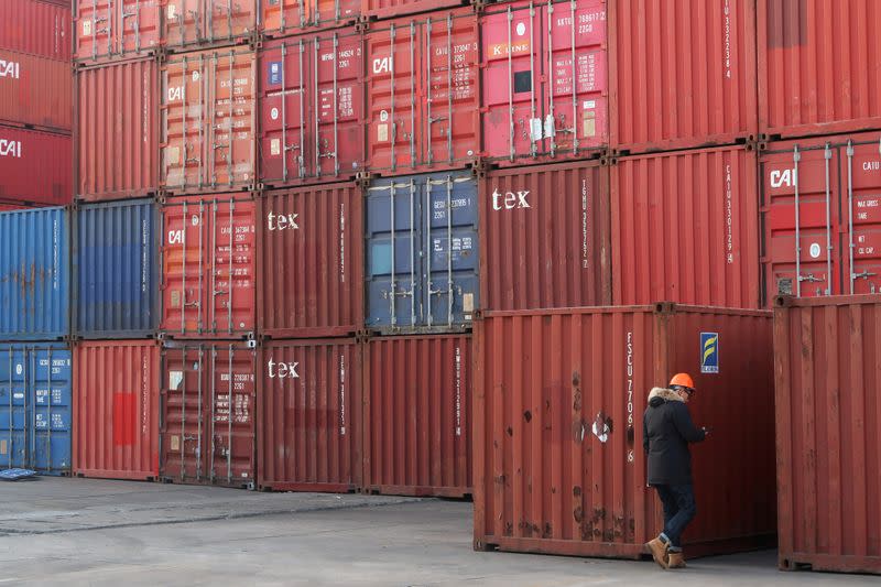 FILE PHOTO: Worker checks containers at a logistics center near Tianjin port, in Tianjin, China