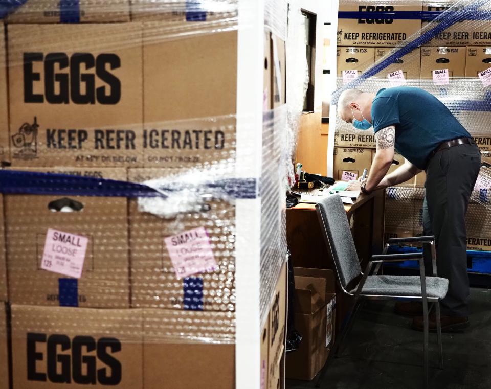 In 2020 a Feeding Northeast Florida food bank employee signs off on batches of eggs donated by Cowford Chophouse and Cal-Maine Foods.