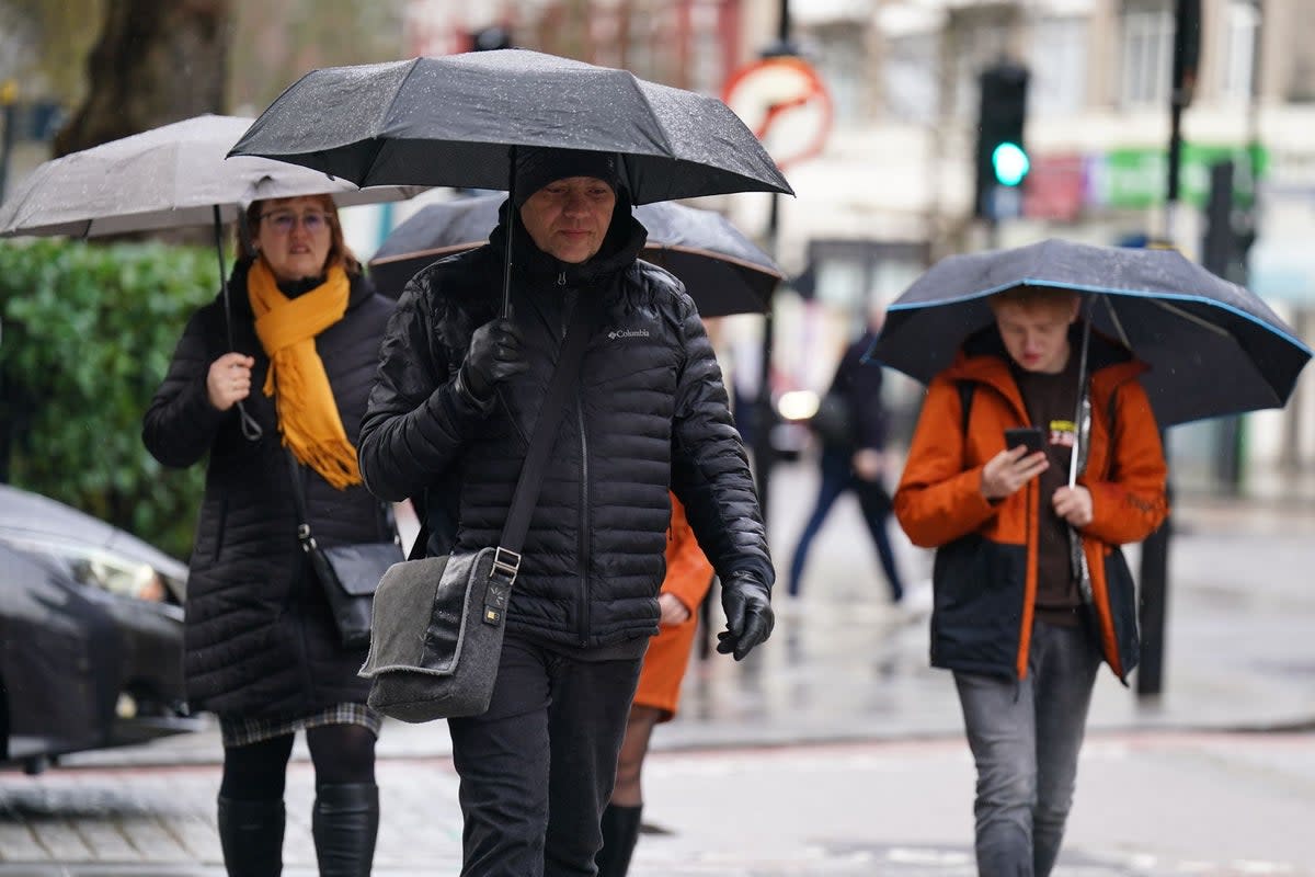 Londoners sheltering from the rain (James Manning/PA Wire)