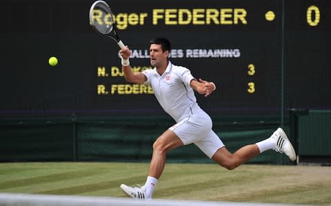 Serbia's Novak Djokovic returns to Switzerland's Roger Federer during their men's singles final match on day thirteen of the 2014 Wimbledon Championships at The All England Tennis Club in Wimbledon. - Credit: AFP