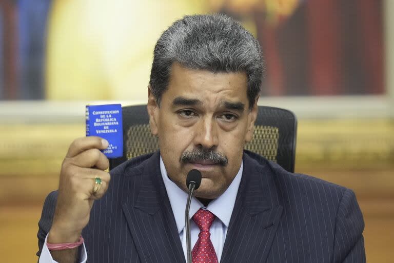 El presidente venezolano, Nicolás Maduro, sostiene una pequeña copia de la Constitución mientras da una rueda de prensa en el palacio presidencial de Miraflores en Caracas, Venezuela, el miércoles 31 de julio de 2024, tres días después de su disputada reelección.