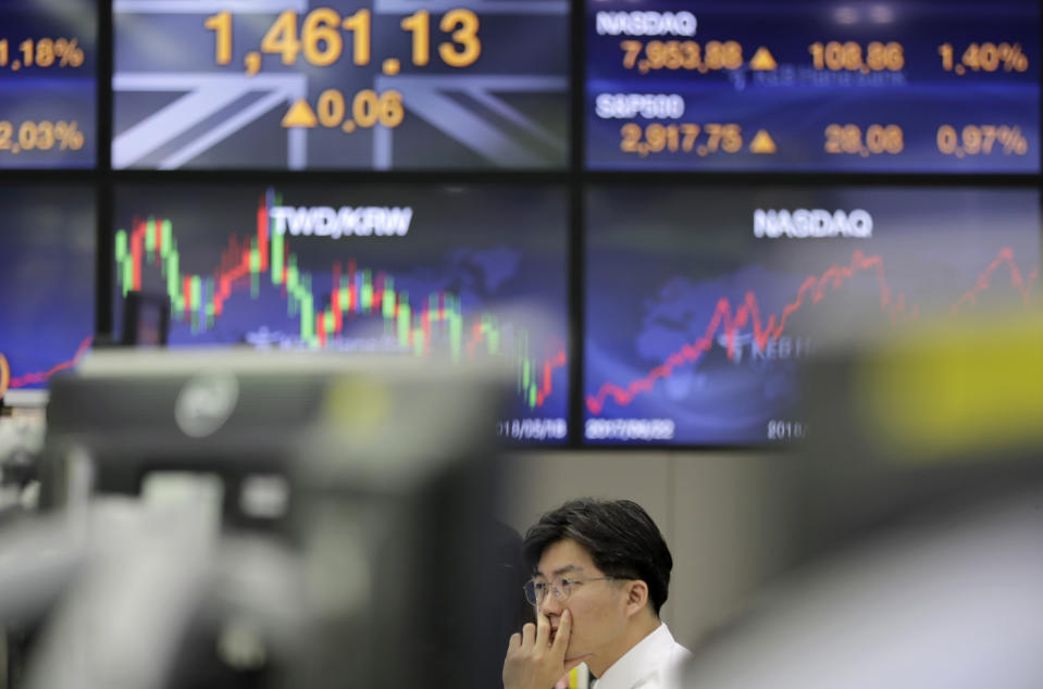 A currency trader watches computer monitors near the screens showing the foreign exchange rates, left, at the foreign exchange dealing room in Seoul, South Korea, Wednesday, June 19, 2019. Asian shares were mostly higher Wednesday on optimism about trade after President Donald Trump said he will talk with the Chinese leader later this month in Japan.(AP Photo/Lee Jin-man)