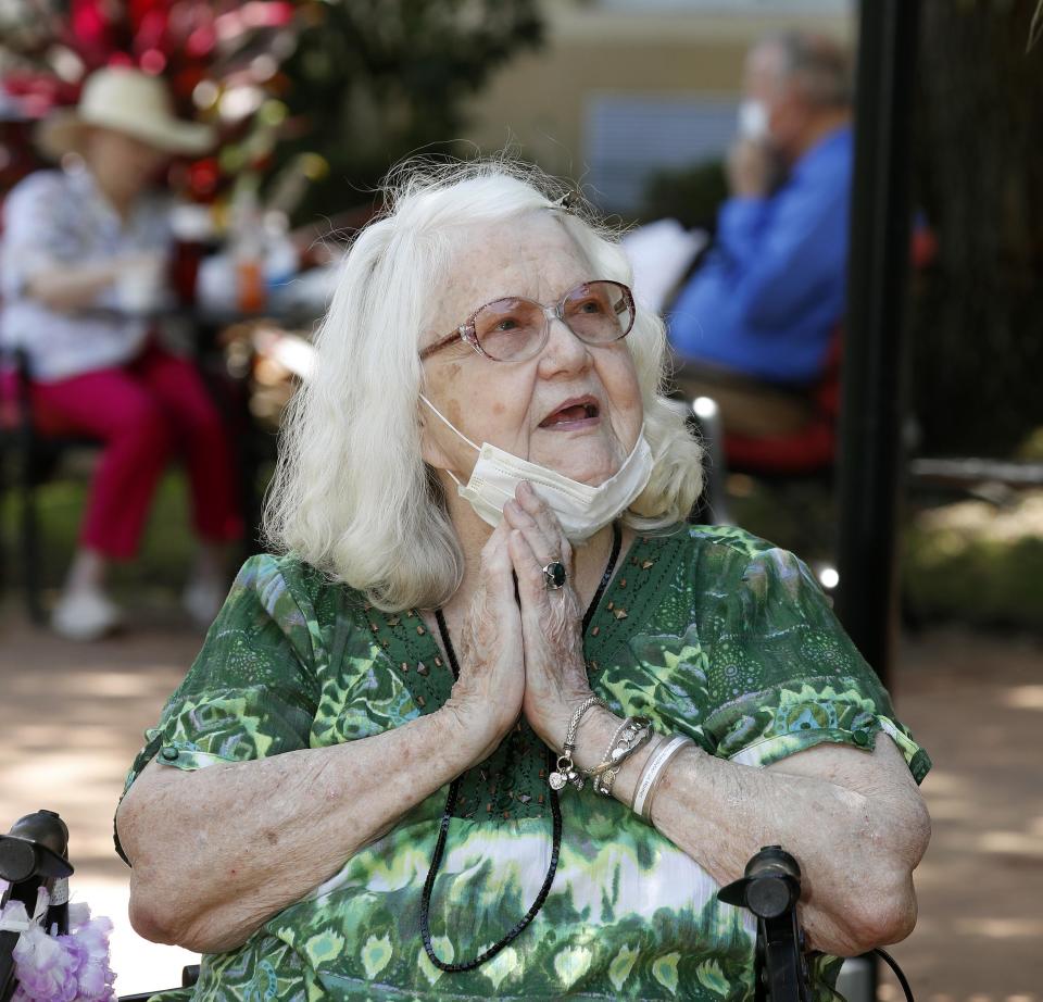 JoAnn Reck, in the courtyard, talks with her husband, Sam Reck, on the balcony at Florida Presbyterian Homes in Lakeland, Florida, in May. When Joann was moved from their apartment into the skilled nursing area of the facility, the couple were separated due to a state mandate closing nursing home visits. However, they would meet three times a week in this distant setting.