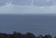 In this image taken from SKY video, shows a tanker at sea, as filmed from land on Sunday Oct. 25, 2020. British police are investigating an undisclosed incident aboard an oil tanker in the English Channel. The incident reportedly took place aboard the Libyan-registered oil tanker Nave Andromeda south of Sandown on Isle of Wight, according to Isle of Wight Radio. (SKY News via AP)