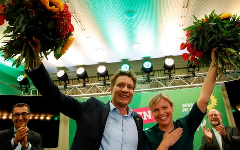 Top candidates of the Greens party in Bavaria Katharina Schulze (R) and Ludwig Hartmann celebrate with flowers on the stage after first exit polls were announced on public television after the Bavaria state election in Munich - Credit: ODD ANDERSEN