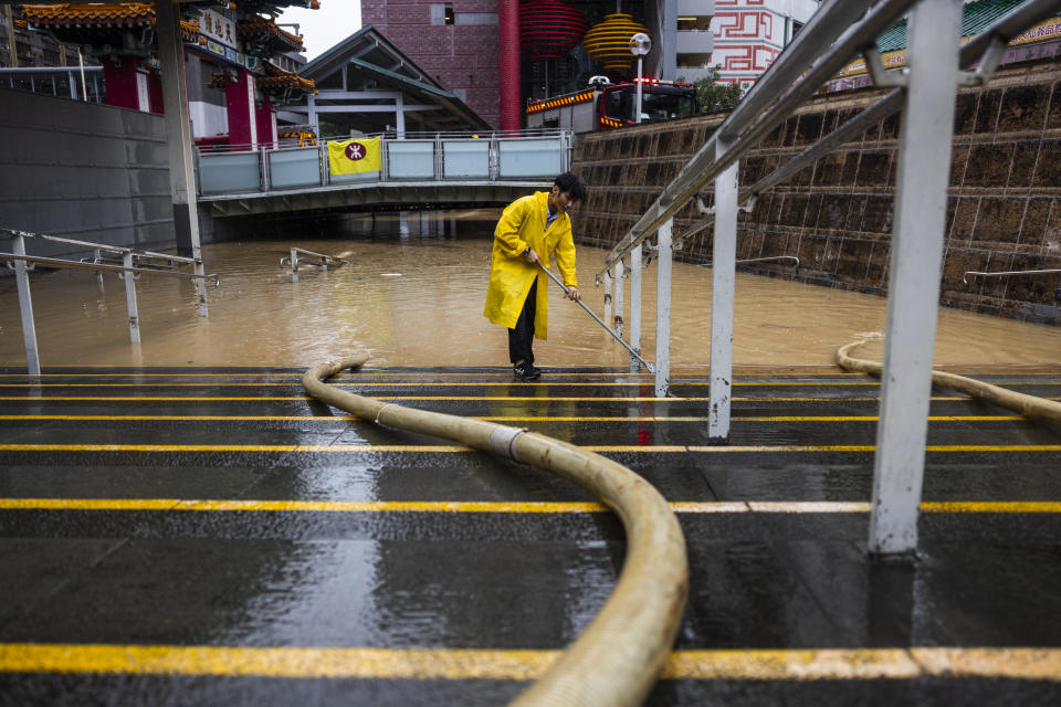 Un operario retira el agua de una calle anegada tras las intensas lluvias caídas en Hong Kong, el 8 de septiembre de 2023. (AP Foto/Louise Delmotte)