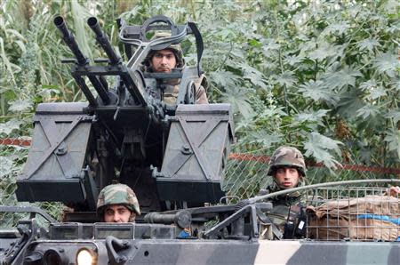 Lebanese army soldiers are seen on their military vehicle as they deployed on the streets of Tripoli, northern Lebanon, December 3, 2013. REUTERS/Stringer