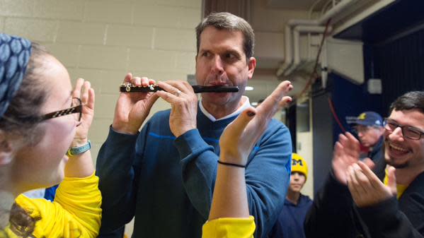 Jim Harbaugh playing piccolo with the U-M band Jan. 24, 2015, at Crisler Center in Ann Arbor.