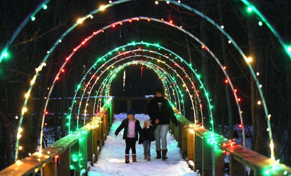 Dawn Cromwell, of Waterford Township, and her granddaughters Rylinn Bradney, left, and Charlee Bradney, center, view the 2020 Winter Wonderland holiday light displays at Asbury Woods in Millcreek Township.