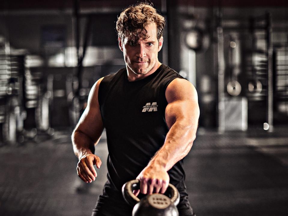 Henry Cavill swinging a kettlebell.