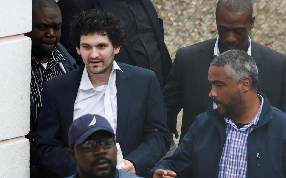 Sam Bankman-Fried being escorted out of the Magistrate Court building in Nassau, Bahamas, on Wednesday - REUTERS/Dante Carrer