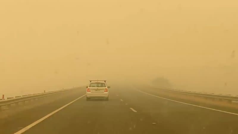 Car drives in smog on the road to Cooma from Canberra in Bredbo