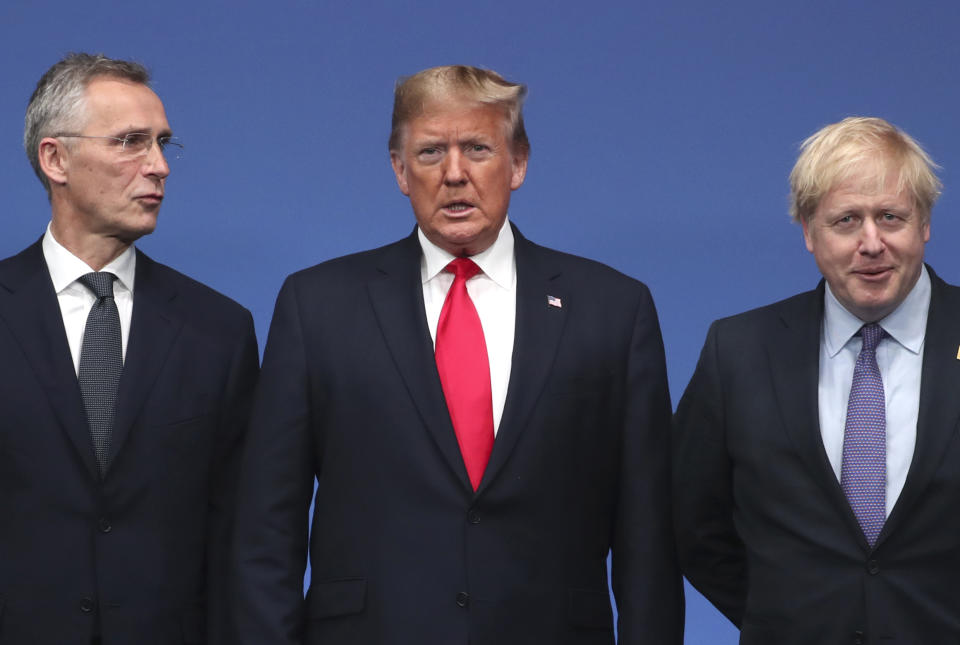 NATO Secretary General Jens Stoltenberg, left, and British Prime Minister Boris Johnson, right, welcome U.S. President Donald Trump during a NATO leaders meeting at The Grove hotel and resort in Watford, Hertfordshire, England, Wednesday, Dec. 4, 2019. NATO Secretary-General Jens Stoltenberg rejected Wednesday French criticism that the military alliance is suffering from brain death, and insisted that the organization is adapting to modern challenges. (AP Photo/Francisco Seco)