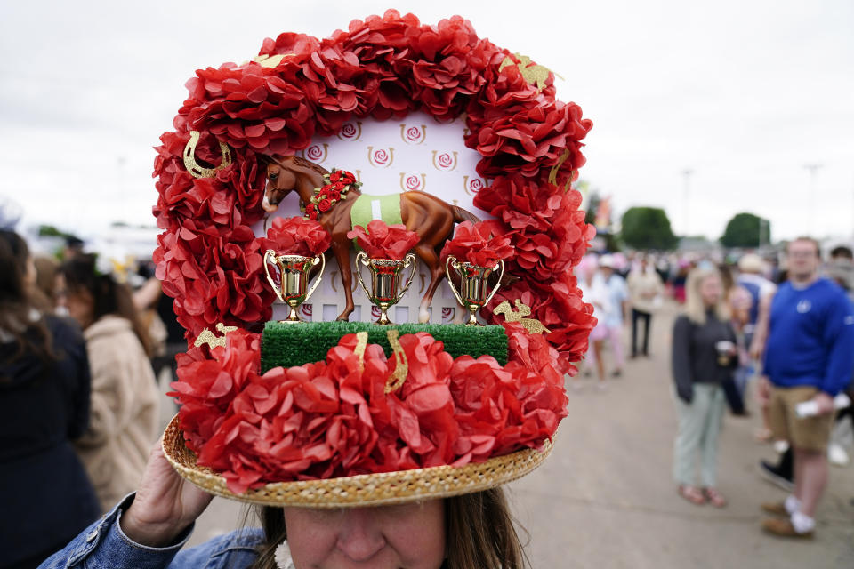 A woman wears a decorative hat as she walks through the infield before the 148th running of the Kentucky Derby horse race at Churchill Downs Saturday, May 7, 2022, in Louisville, Ky. (AP Photo/Brynn Anderson)