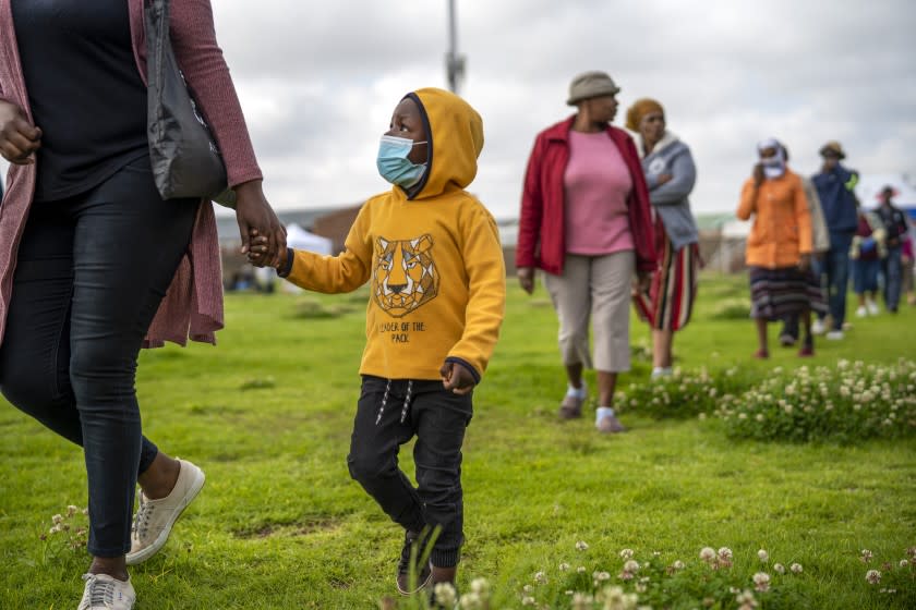 Residents from the Alexandra township in Johannesburg gather in a stadium to be tested for COVID-19 Monday, April 26, 2020. South Africa will began a phased easing of its strict lockdown measures on May 1, although its confirmed cases of coronavirus continue to increase. (AP Photo/Jerome Delay)