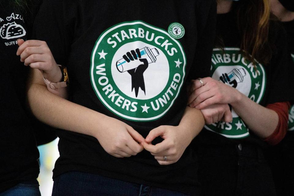 FILE - Starbucks employees and supporters link arms during a union election watch party Dec. 9, 2021, in Buffalo, N.Y. (AP Photo/Joshua Bessex, File)