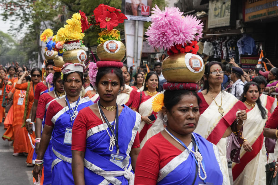 Tribal women with pitcher on their head join a rally by the Trinamool Congress party on the eve of International Women's Day in Kolkata, India, Thursday, March 7, 2024. (AP Photo/Bikas Das)