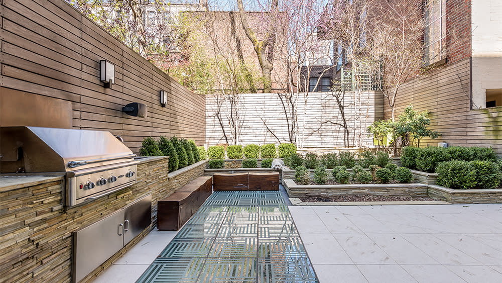 The home’s terrace includes lavish landscaping and an al fresco kitchen. - Credit: Compass