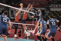 Argentina's Facundo Conte spikes a ball past Maxwell Holt, #12, and Taylor Sander, of the United States, during a men's volleyball preliminary round pool B match, at the 2020 Summer Olympics, early Monday, Aug. 2, 2021, in Tokyo, Japan. (AP Photo/Manu Fernandez)