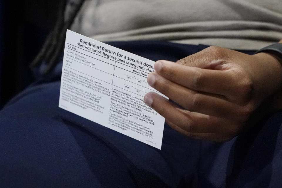 Jniya Tallie, a graduate assistant with the Jackson State women's basketball team, fiddles with her vaccination card after receiving her second dose of the Pfizer vaccine at an open COVID-19 vaccination site sponsored by the university and the Jackson-Hinds Comprehensive Health Center in the Rose E. McCoy Auditorium at Jackson State University in Jackson, Miss., Tuesday, July 27, 2021. (AP Photo/Rogelio V. Solis)