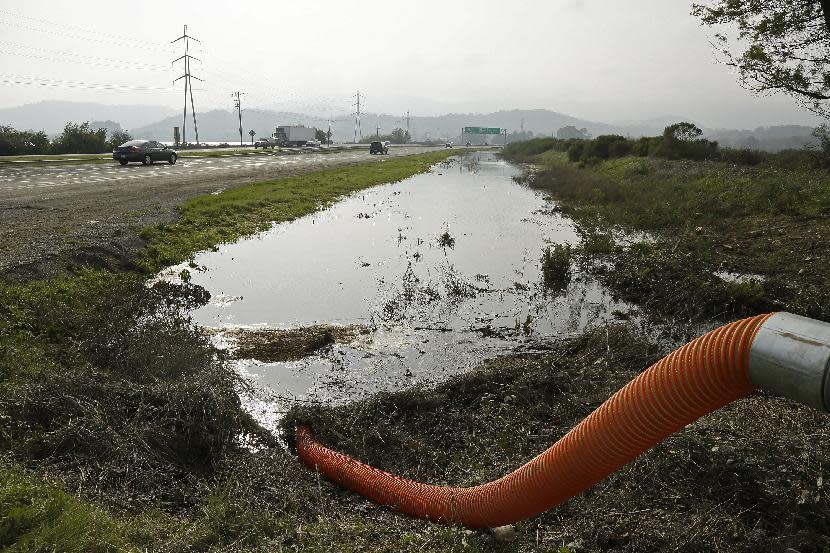 In this Tuesday, Jan. 17, 2017, photo, a pump removes water from a flooded are along Highway 37 near Novato, Calif. Ocean rise already is worsening the floods and high tides sweeping California this stormy winter, climate experts say, and this month's damage and deaths highlight that even a state known as a global leader in fighting climate change has yet to tackle some of the hardest work of dealing with it. (AP Photo/Eric Risberg)