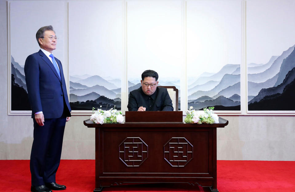 <p>North Korean leader Kim Jong Un signs a guest book next to South Korean President Moon Jae-in, left, inside the Peace House at at the border village of Panmunjom in Demilitarized Zone Friday, April 27, 2018. (Photo: Korea Summit Press Pool via AP) </p>