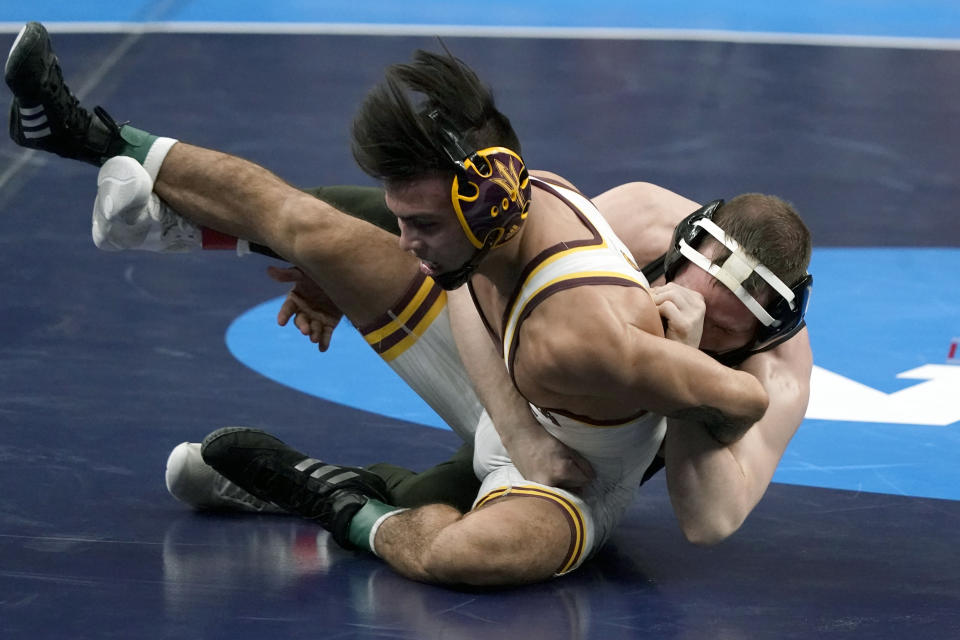 Iowa's Spencer Lee, right, takes on Arizona State's Brandon Courtney during their 125-pound match in the finals of the NCAA wrestling championships Saturday, March 20, 2021, in St. Louis. (AP Photo/Jeff Roberson)