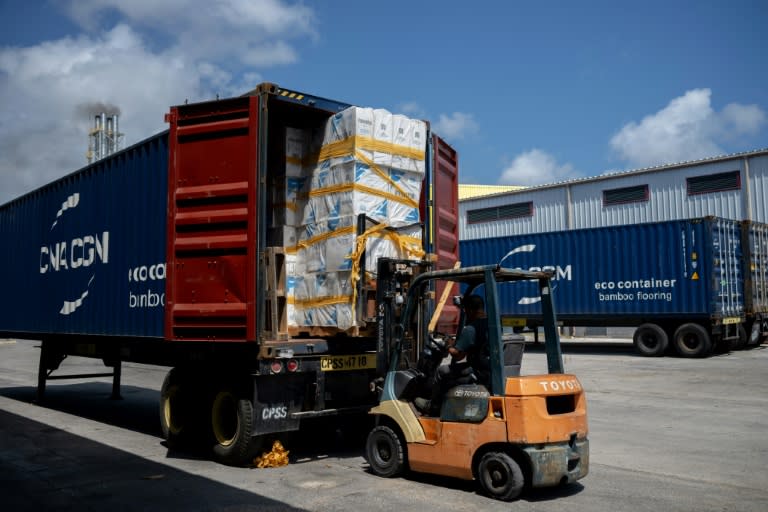 Trabajadores cargan mercancía en un camión en la Zona Franca del puerto en Willemstad, Curazao, el 14 de marzo de 2024 (Federico PARRA)