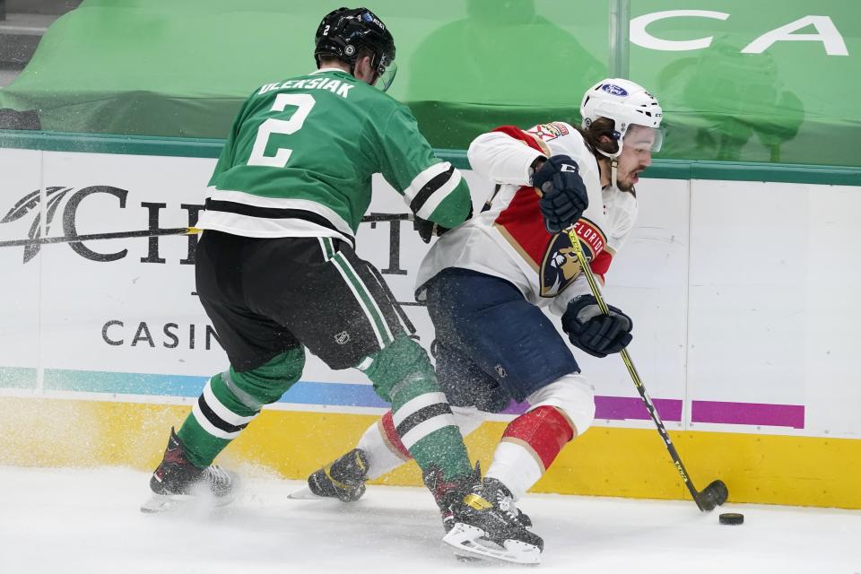 Dallas Stars defenseman Jamie Oleksiak (2) pressures Florida Panthers left wing Ryan Lomberg (94) as he handles the puck in the first period of an NHL hockey game in Dallas, Saturday, April 10, 2021. (AP Photo/Tony Gutierrez)