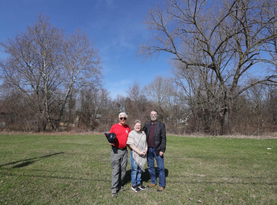 Christina Surgeon, center, with retired Akron firefighters Larry Steele, left, and David Sullivan  March 12 in Akron. The firefighters stand on Kenmore Boulevard, where they fought the 1972 fire Surgeon survived. The blaze killed three children and Surgeon's mother.