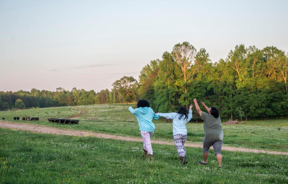 Girls from the ranch frolic together through a pasture after helping herd cattle at the Tallapoosa County Girls’ Ranch in Camp Hill, Ala., on Tuesday, April 26, 2022.