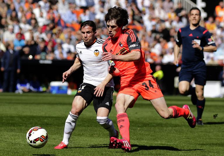 Valencia's Argentinian forward Pablo Piatti (L) vies with Real Sociedad's defender Julen Etxabeguren during the Spanish league football match at the Mestalla stadium in Valencia on March 1, 2015